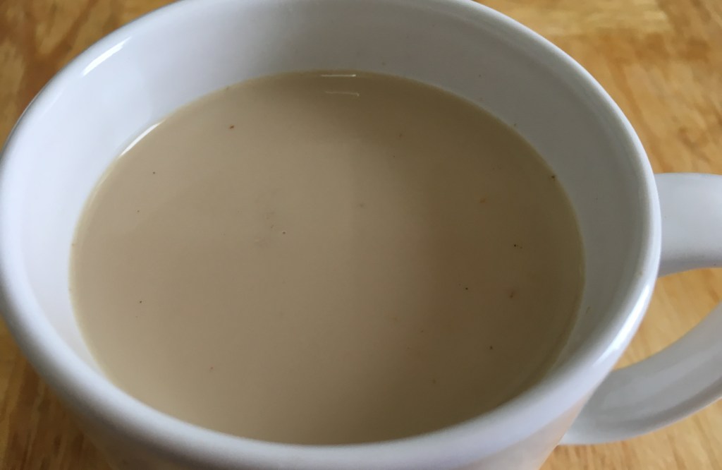masala chai in a white mug on a wood surface